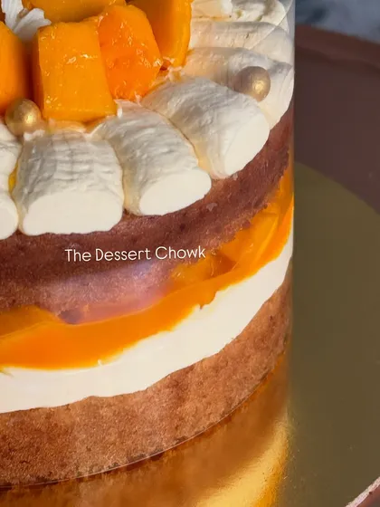 A peek inside my pull-me-up style mango cake, showing the delicious layers of sponge, mango mousse, and fresh fruit.