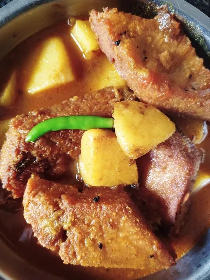 A bowl of traditional Dhokaar Dalna. These are savoury lentil cakes, first fried to a golden brown and then simmered in a light, spiced gravy with potatoes. It’s a vegetarian showstopper that even non-vegetarians love.
