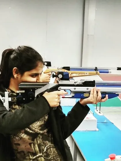 A young shooter demonstrates excellent form with her competition-grade air rifle. We focus on teaching the correct ergonomics and posture from day one.