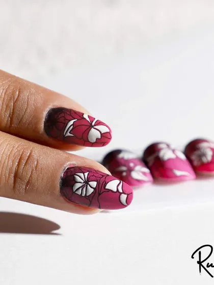 A close-up of the floral stamping art on a client's hand.