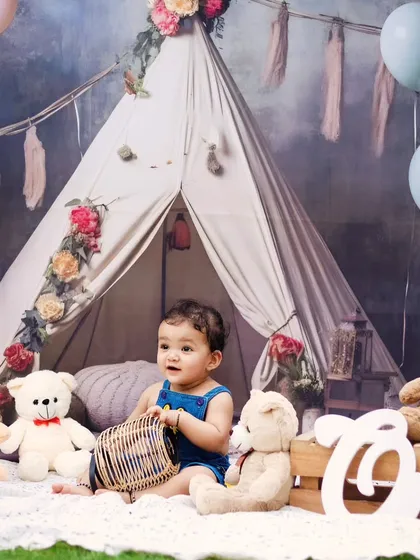 A baby boy playing with a basket in our rustic boho-themed setup.