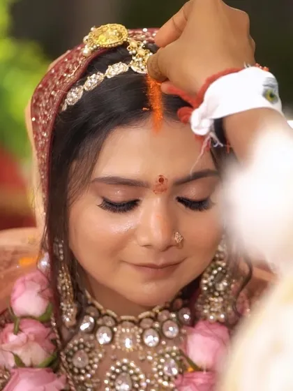 A close-up during the sindoor ceremony, highlighting the makeup's precision and durability. Even in intimate, emotional moments, the look remains impeccable, with defined lashes and a smooth skin finish.