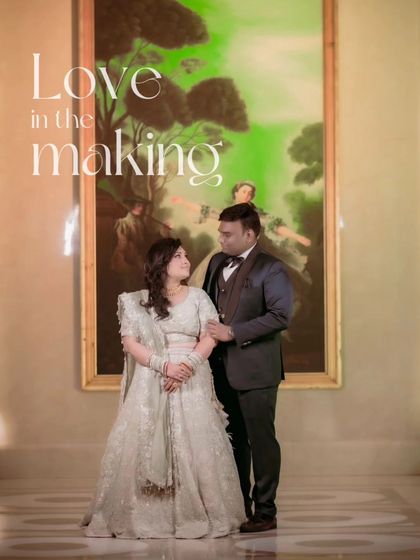 "Love in the making." The couple stands before a large painting, their pose echoing the art behind them. This shot blends their love story with a touch of classic artistry.