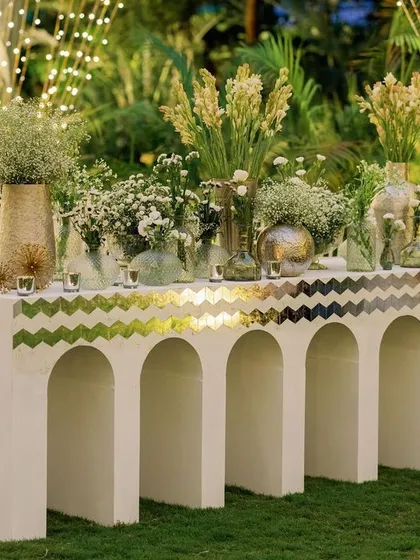A custom-built bar counter featuring arched details and a chevron-patterned Thikri mirror top. It’s a functional element turned into a piece of art, serving drinks while enhancing the overall aesthetic of the sangeet.