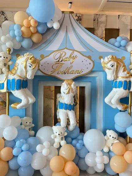 To welcome a baby boy, we designed a beautiful carousel-themed setup with pastel blue and peach balloons, classic carousel horses, and adorable teddy bears.