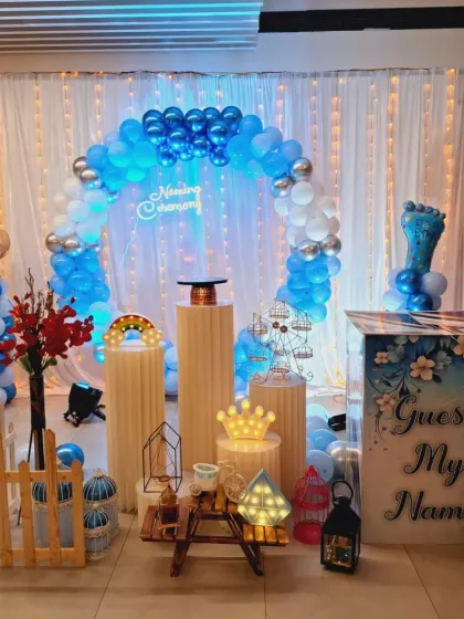 Another angle of the boy's naming ceremony setup, highlighting the 'Naming Ceremony' neon sign and the arrangement of props.