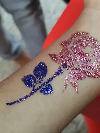A two-toned rose in sparkling pink and deep blue. This color combination offers a modern twist on a classic floral tattoo design.