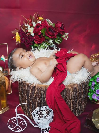 Another joyful shot of the baby on the log, looking up with a big smile.