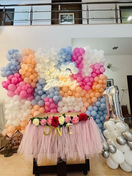 Another angle of the stunning pastel balloon wall, showing the 'ONE' letters on the cake table for a first birthday.