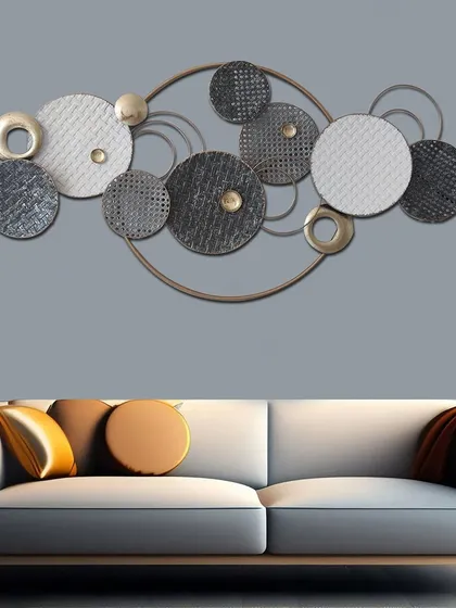 Ornate and opulent, this metal wall art features intertwined discs with various textures in a baroque construction. The gold, silver, and black finishes create a luxurious and avant-garde look.
