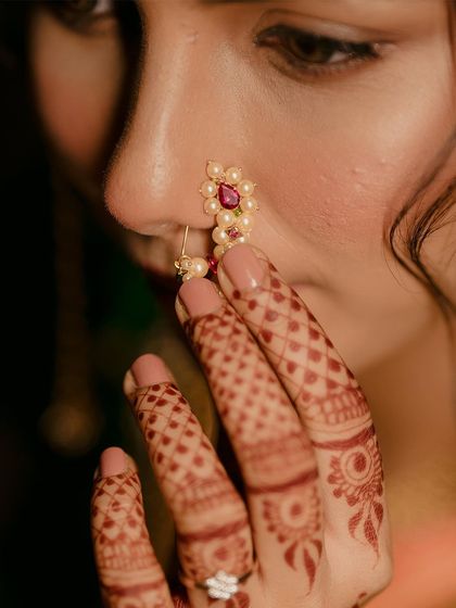 A detailed close-up of the bride's traditional Marathi nath (nose ring), a key element of her stunning bridal look.
