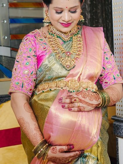 Another beautiful shot of our client celebrating her baby shower. The antique gold jewellery with green beads adds a traditional charm to her special day.