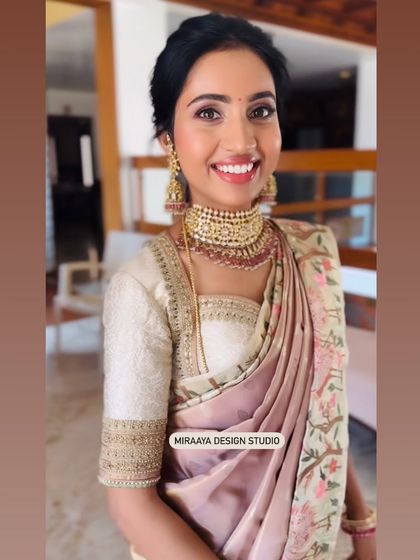 A happy smile from my client Nithya. This close-up shows the delicate embroidery on the sleeves of her custom blouse, which adds a touch of sparkle to her look.