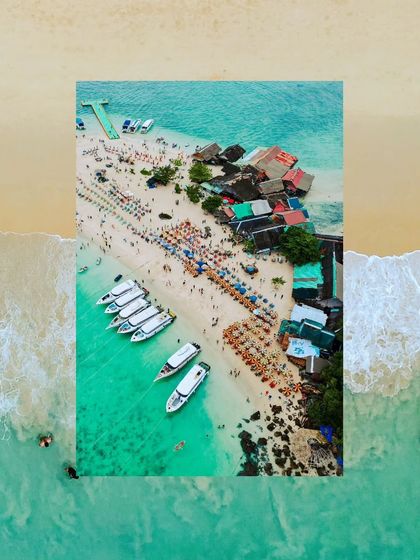 A bustling beach scene in Thailand from above, showing the vibrant activity of a popular tourist spot with boats, umbrellas, and beachside shacks.