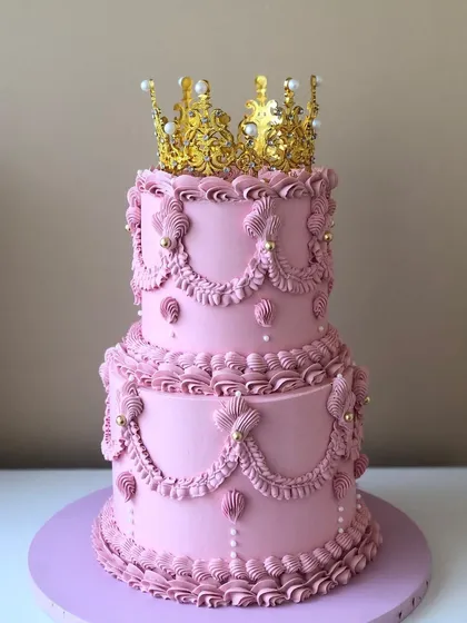 I love bringing vintage charm to life with buttercream. This two-tiered pink Lambeth cake, with its intricate piping and a regal gold crown, was perfect for a princess-themed birthday.