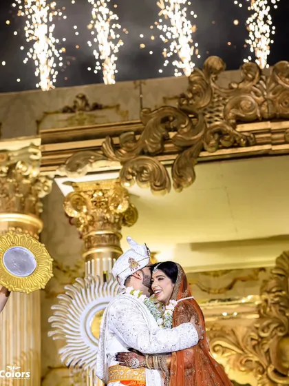 The couple shares an embrace on stage as fireworks go off behind them. A perfect, high-energy shot to capture the peak of the celebration.