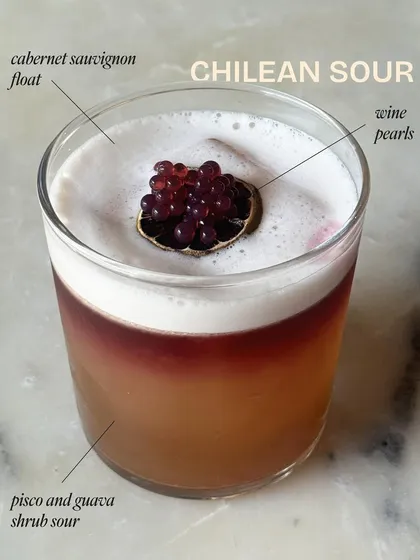 Deconstructing the Chilean Sour. This annotated view shows the layers of our craft: a pisco and guava shrub sour, deepened by a cabernet float and finished with delicate wine pearls.