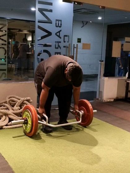 A client setting up for a trap bar deadlift, a foundational movement for building full-body strength.