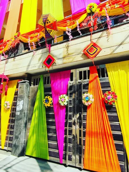 A colourful gate decoration with drapes and hanging traditional elements, perfectly complementing the fully decorated house exterior.