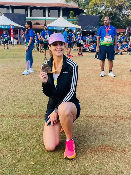 A smile of satisfaction after a new personal best. This runner's hard work paid off on a challenging rolling course, proving that strength training is a critical part of race performance.