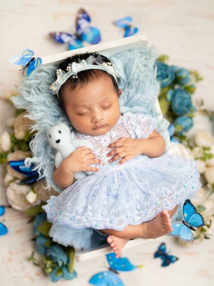 Dreaming amongst the butterflies. This setup uses a beautiful blue color palette with delicate floral and butterfly accents to create a serene and enchanting scene for this baby girl.