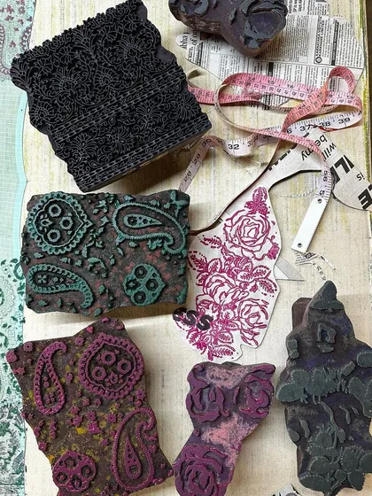 A flat lay showing the combination of vintage blocks and fabric swatches for a summer kota saree. We love mixing timeless floral and paisley prints to create a unique and dreamy aesthetic.