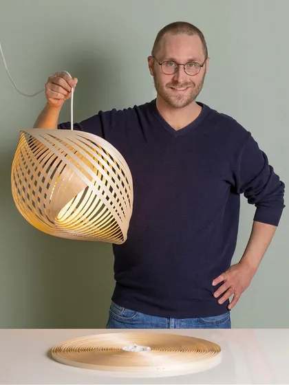 The Adilo lamp, a sustainable and timeless piece of Scandinavian wooden lighting. Designer Ilkka Kauppinen demonstrates how the flat-packed birch plywood unfurls into this beautiful, sculptural form.