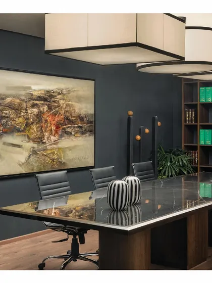 The grand conference room where it all comes together. A large abstract painting hangs on a dark grey wall, reflecting in the polished marble tabletop. The space is designed to be impressive and conducive to important decisions.