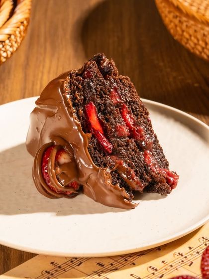 A single, perfect slice of our Boozy Nutella Strawberry cake. The rum-infused sponge perfectly complements the rich chocolate and tangy strawberries for a bold, balanced dessert.