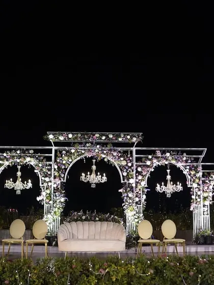 The mandap for Reeya and Parth's wedding, illuminated at night. The combination of floral arches, elegant chandeliers, and soft lighting created a magical and romantic atmosphere for their evening ceremony.