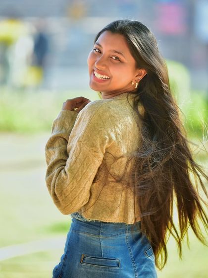 A joyful, over the shoulder smile with her long hair flowing. This is a perfect example of a bright, happy portrait that feels full of life and energy.