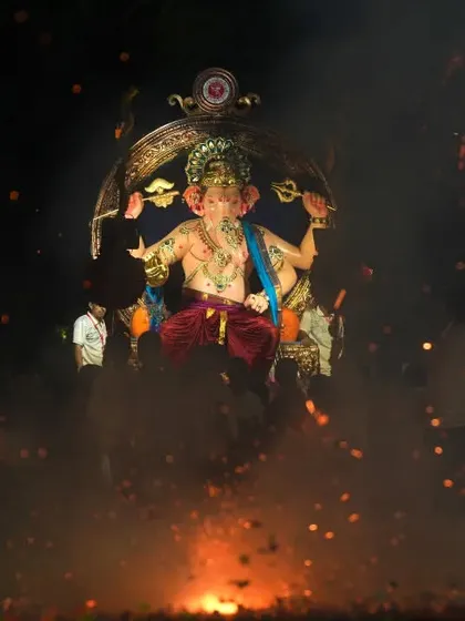 Capturing the raw energy of the Ganesh festival with sparks and smoke at the base of the Sanpada Cha Raja idol.
