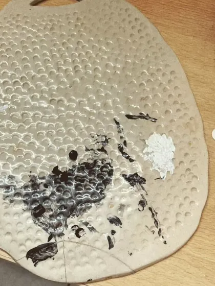 The cracks and textures on this broken platter now hold paint instead of cheese. It's a reminder that challenges can lead to creative solutions and unexpected beauty.