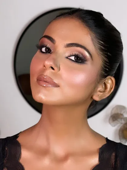 A finished shot of this beautiful soft glam look on dusky skin. The makeup features a shimmery eye and a glossy nude lip, with a focus on glowing, radiant skin.