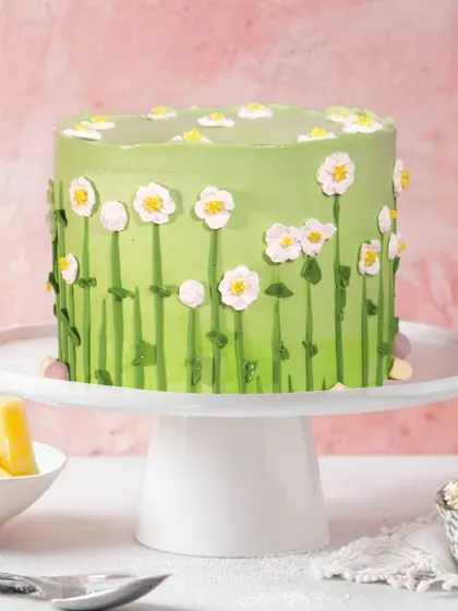 A charming pineapple cake decorated with a field of hand-piped daisies. This fresh and simple design is as delightful to look at as it is to eat.
