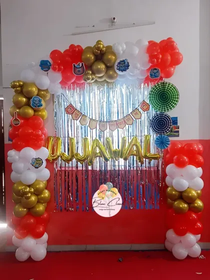 A simple wall decoration in red, white, and gold. This setup is perfect for creating a small and festive photo corner for a birthday party.
