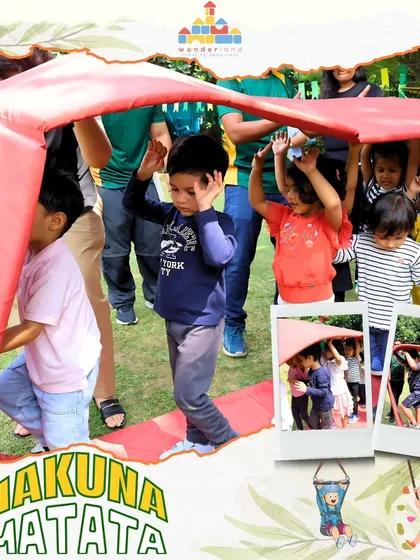 Teamwork makes the dream work. Children work together to move under a large red fabric, learning cooperation and coordination in a fun, physical challenge at our camp.