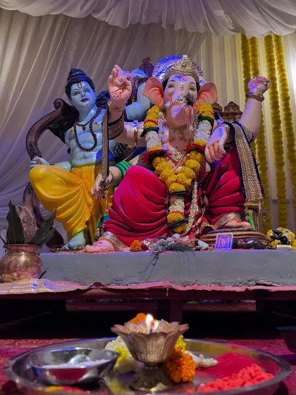 A close-up of the main idol at the 'Gokul Nagari Cha Maharaja' event. The lighting and simple background ensure the focus remains on the divine figures, creating a serene atmosphere for devotees.