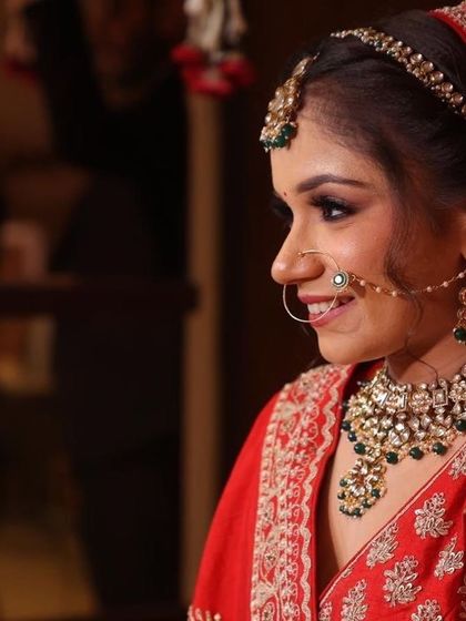 A smiling side profile of bride Aarushi, showing her delicate nath and kundan choker.