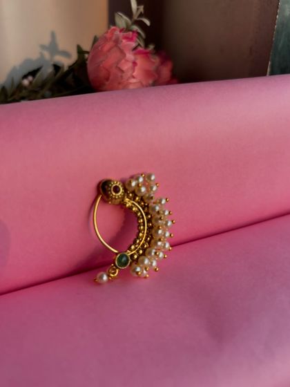 A slightly different angle of the pearl nath, showing its curved shape.