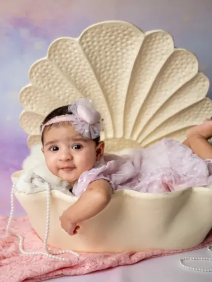 Beauty in a shell of love. This pose is perfect for showing off your baby's sweet, sleepy face.