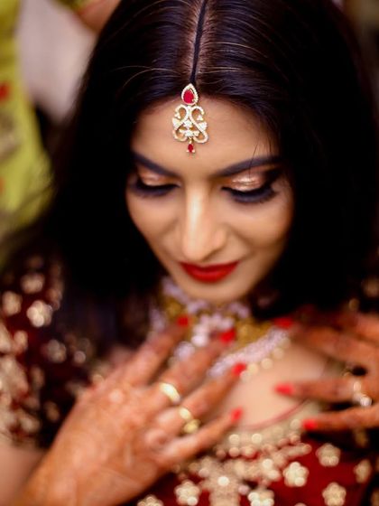 A bride adjusting her necklace. This shot highlights the beautiful jewelry and the final preparations for the big event.