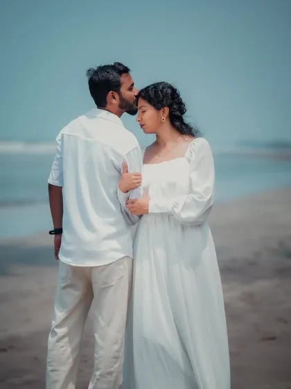 A gentle kiss on the forehead against the backdrop of the sea. This photo is a simple, beautiful, and timeless expression of love and care, perfect for a pre-wedding shoot.