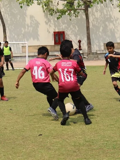 The intensity of a real match is where lessons are truly learned. Our players are locked in a battle for possession during a DFA League game, demonstrating the tactical awareness and competitive spirit we instill in every training session.