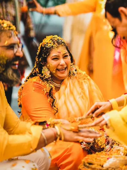 Laughter and love fill the air at this Haldi ceremony. This candid shot captures a genuine moment of happiness and family bonding during the pre-wedding rituals.