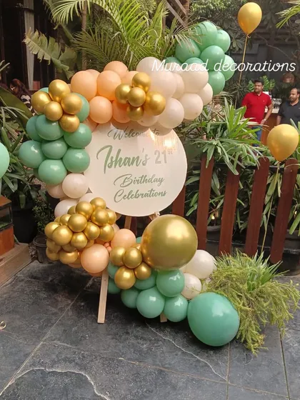 A welcome sign for a 21st birthday celebration. The organic balloon arrangement in mint, peach, and gold creates a fresh and modern look for this outdoor garden party.