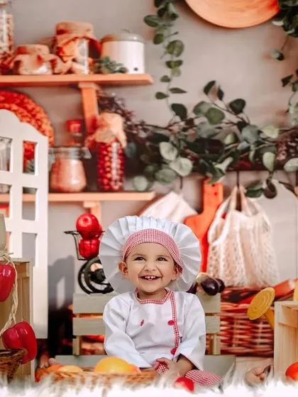 A huge, happy smile from our little chef. Her joy is absolutely infectious in this fun and creative kitchen-themed photoshoot.