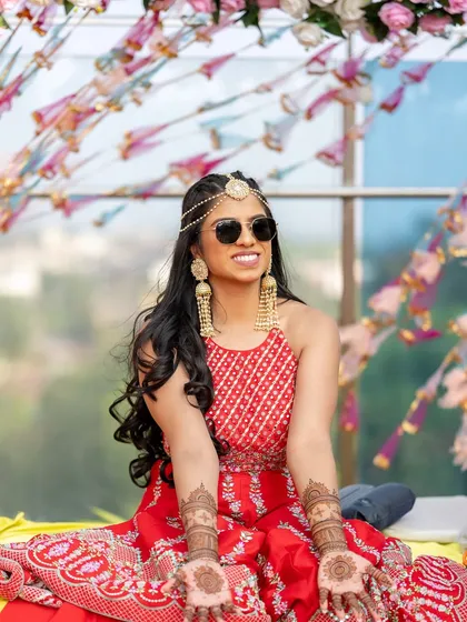 Mehendi magic with a cool pair of sunglasses. This bride is all about having fun, and her makeup is bright and shimmery to match her vibe.