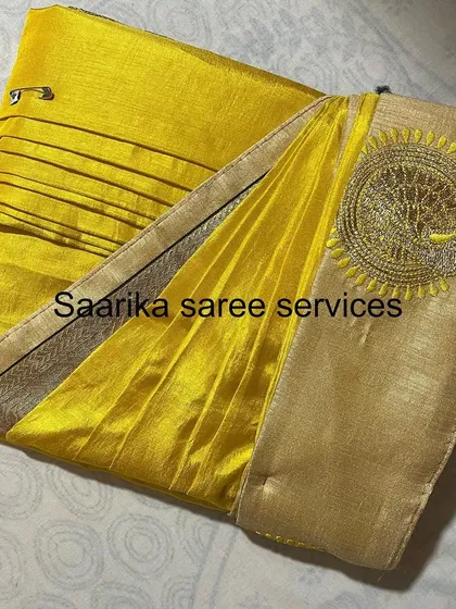 A bright yellow saree with a unique embroidered peacock on the pallu.