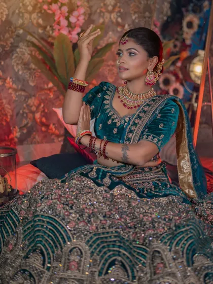 A classic pose that highlights the intricate embroidery and rich colour of the outfit.